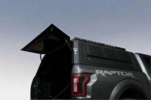 Side view of heavy-duty steel truck topper on black pickup
Modular canopy with open gullwing side door
Lockable utility cap rear view
Installation components of modular truck canopy
Steel topper installed on full-size pickup truck