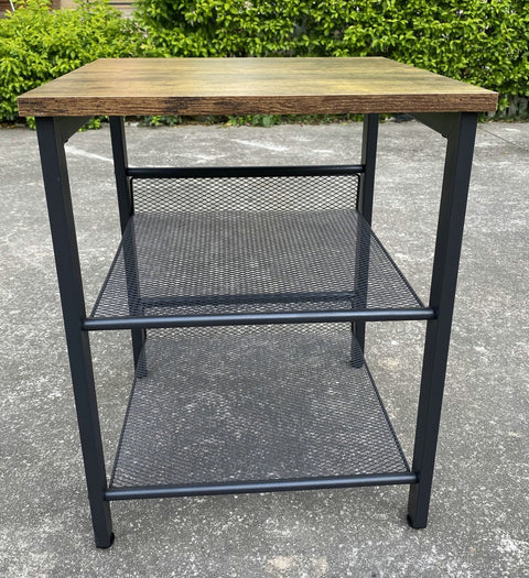 Rustic end tables in a cozy living room setting with sofa and lamp
Side View: Square wood top table with black mesh shelf
Angled View: Rustic wood and black metal table with adjustable shelf
Front View: Front profile of industrial end table with wood top and mesh shelf
Top View: Close-up of wood grain tabletop with rounded edges