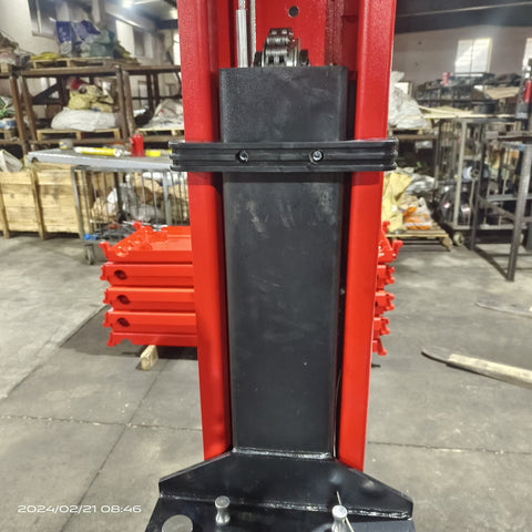 2-post vehicle lift in red installed in garage
Close-up of lifting arms and safety lock mechanism
Base of hoist with truck tires for scale
Top bar and hydraulic system – JH5000F model