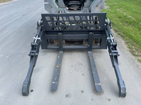 Front view of skid steer pipe grapple with clamp arms
Side view showing 48-inch clamp arm forks in use
Pipe grapple lifting construction material
Close-up of dual hydraulic clamp system