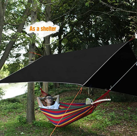Camping tarp with aluminum stakes and wind ropes laid out
4-in-1 waterproof tarp in use as rain shelter in forest
Black tarp covering picnic area in outdoor campsite
Folded tarp in carry bag with accessories shown separately