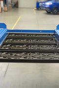 Blue portable 4-post car hoist in garage

Drive-on ramp and runway surface

Close-up of power unit and lift columns

Vehicle elevated on blue car lift

Heavy-duty safety locks and cable system