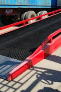 Red heavy-duty stationary dock ramp for forklift access