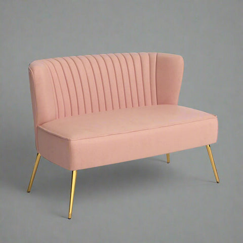 Fuchsia velvet loveseat with tufted back and gold legs in modern decor.
Ivory armless loveseat sofa with mid-century design in studio setup.
Tan velvet 2-seater with flared gold legs styled against a neutral wall.
Close-up of plush velvet texture and fluted backrest detail.
Color swatches displaying Fuchsia, Pink, Ivory, and Tan options.