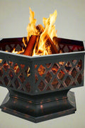 Hexagon wood burning fire pit lit outdoors for backyard warmth