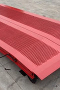 Side view of 10x25 red steel loading dock ramp with safety rail