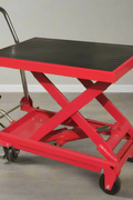 Side view of heavy-duty red scissor lift table cart with steel frame and platform