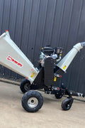 15 HP Kohler electric start wood chipper – trailer mounted front view
Side profile of 420cc wood chipper with hitch and tires
Chipper machine close-up showing large intake chute and rotor
Kohler engine wood chipper parked outdoors with debris