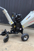 15 HP Kohler electric start wood chipper – trailer mounted front view
Side profile of 420cc wood chipper with hitch and tires
Chipper machine close-up showing large intake chute and rotor
Kohler engine wood chipper parked outdoors with debris