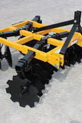 8 ft yellow 3-point tractor disc harrow with notched blades/
Close-up of notched disc blades, double taper bearing system