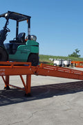 Side view of red adjustable steel dock ramp for trucks