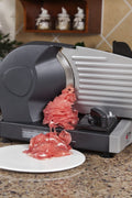 7.5 inch electric meat and deli slicer on kitchen counter
Adjustable food thickness dial and stainless steel blade
Compact electric slicer with food pusher in use
Top view of food slicer showing aluminum body
Deli meat sliced using electric food cutter