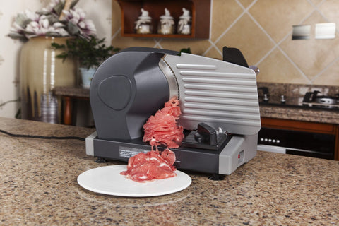 7.5 inch electric meat and deli slicer on kitchen counter
Adjustable food thickness dial and stainless steel blade
Compact electric slicer with food pusher in use
Top view of food slicer showing aluminum body
Deli meat sliced using electric food cutter