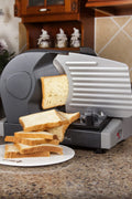 7.5 inch electric meat and deli slicer on kitchen counter
Adjustable food thickness dial and stainless steel blade
Compact electric slicer with food pusher in use
Top view of food slicer showing aluminum body
Deli meat sliced using electric food cutter