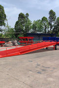 Heavy-duty loading dock ramp with red grating on asphalt yard

Forklift-compatible yard ramp side view with guardrails

Industrial dock ramp base plate and wheels

Side profile of 8 ft wide portable dock ramp

Ramp surface with serrated anti-slip steel close-up