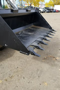80" skid steer digging bucket with removable teeth

Heavy-duty bucket on job site with loader

Front view of 84-inch skid steer bucket

Skid steer digging into dirt with steel bucket

Wear strips and teeth close-up for material handling