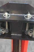 Red 2-post car hoist installed in garage

Close-up of safety lock and lift arms

Base of the lift showing manual release system

Top bar and symmetrical arm configuration