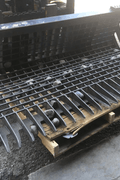 96" skid steer rock bucket with ½" spacing

Heavy-duty skeleton rock bucket on gravel

Close-up of angled bar structure

72" deluxe rock grapple for small rocks and debris

Skid steer lifting rock bucket attachment

