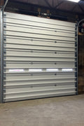 White insulated electric overhead garage door installed in shop
Heavy-duty motorized overhead garage door with steel frame
Electric garage door kit with insulation for industrial buildings
Overhead sectional garage door installed on warehouse