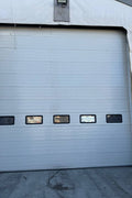 White insulated electric overhead garage door installed in shop
Heavy-duty motorized overhead garage door with steel frame
Electric garage door kit with insulation for industrial buildings
Overhead sectional garage door installed on warehouse