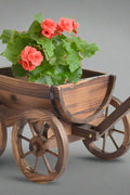 "Rustic wagon wheel planter with burnt wood finish"

"Half barrel garden planter with iron wheels"

"Country-style wooden flower pot for patios and balconies"

"Vintage decorative garden barrel planter WWP43"