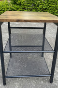 Rustic end tables in a cozy living room setting with sofa and lamp

Side View: Square wood top table with black mesh shelf

Angled View: Rustic wood and black metal table with adjustable shelf

Front View: Front profile of industrial end table with wood top and mesh shelf

Top View: Close-up of wood grain tabletop with rounded edges