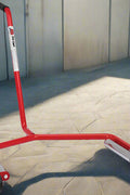 Red truck tire changing dolly with heavy-duty steel frame and caster wheels

