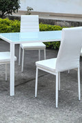 White glass dining table set with 4 chairs in the bright kitchen
Close-up of white glass table and upholstered chair
Side angle of a full 5-piece dining set
White dining chairs around a modern glass table
Dining set outdoors showing full product design
