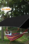 Camping tarp with aluminum stakes and wind ropes laid out
4-in-1 waterproof tarp in use as rain shelter in forest
Black tarp covering picnic area in outdoor campsite
Folded tarp in carry bag with accessories shown separately